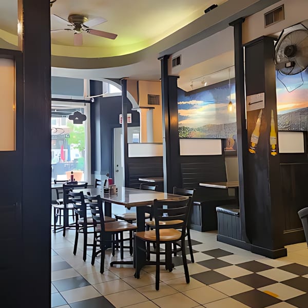 Interior of El Mexican Restaurant with tables, chairs, booths, and a mural on the wall.