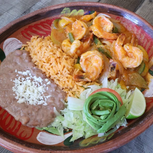 El Mexican Restaurant's shrimp dish with rice, refried beans, lettuce, avocado, tomato, and lime.
